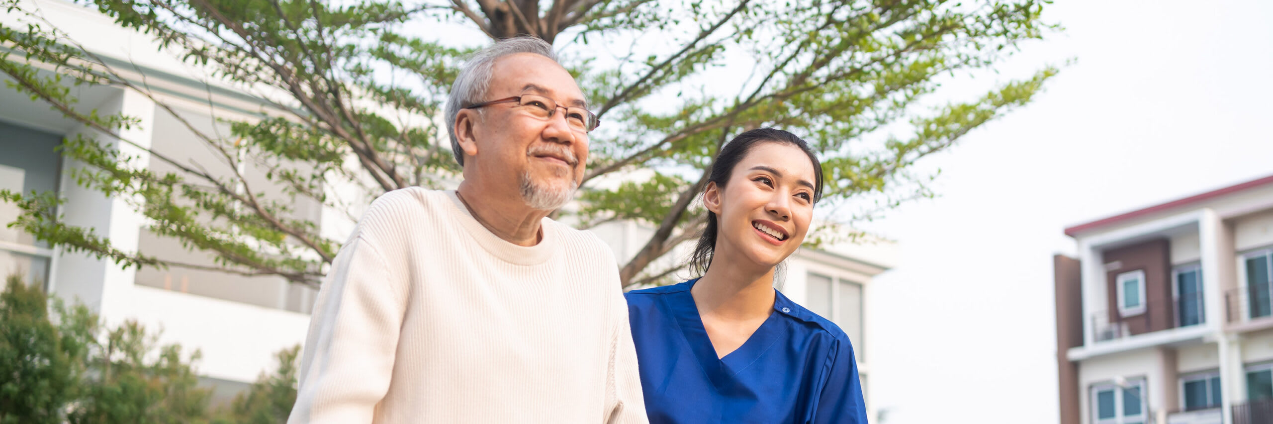 A caregiver providing support to a senior while outside