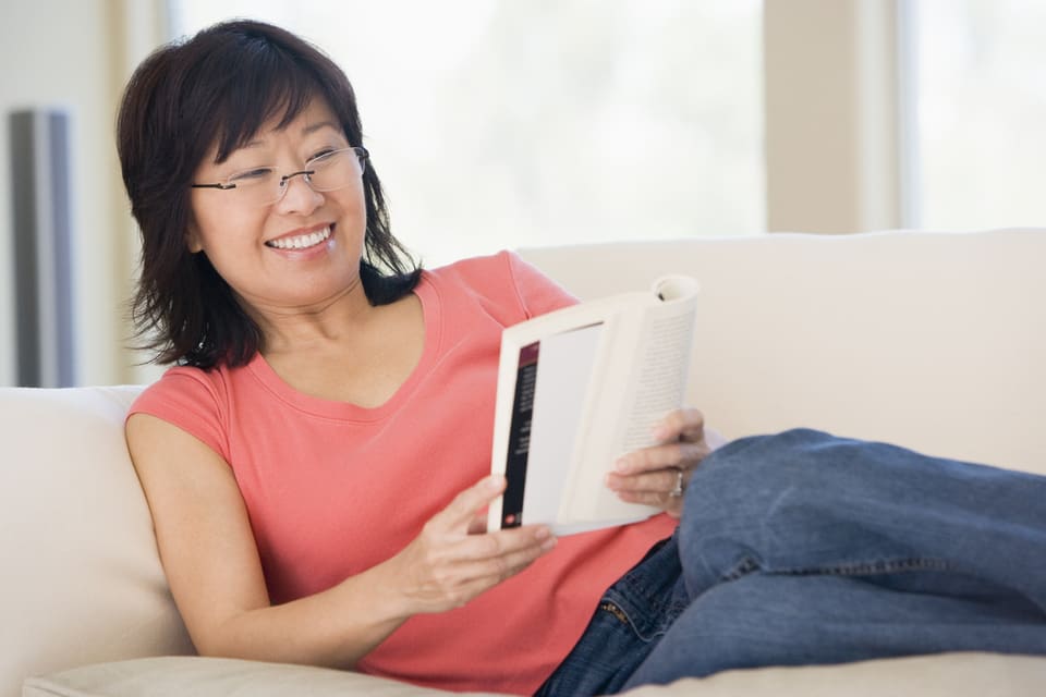 Woman reading a book on a couch