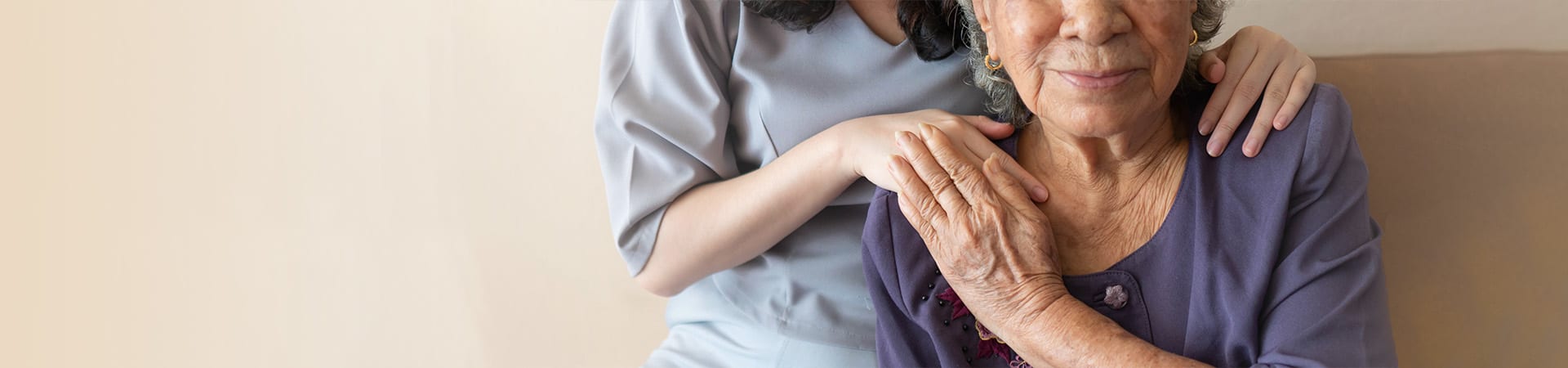 A caregiver puts her hand on a senior women's shoulder