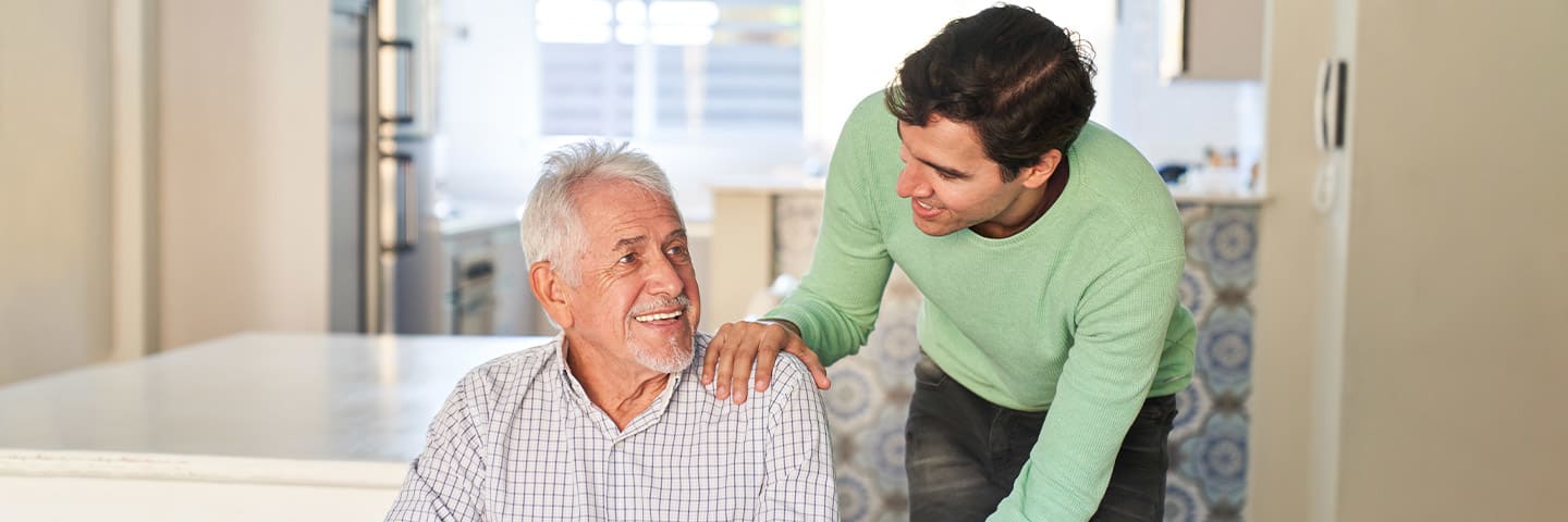 Smiling senior in wheelchair chatting with their caregiver